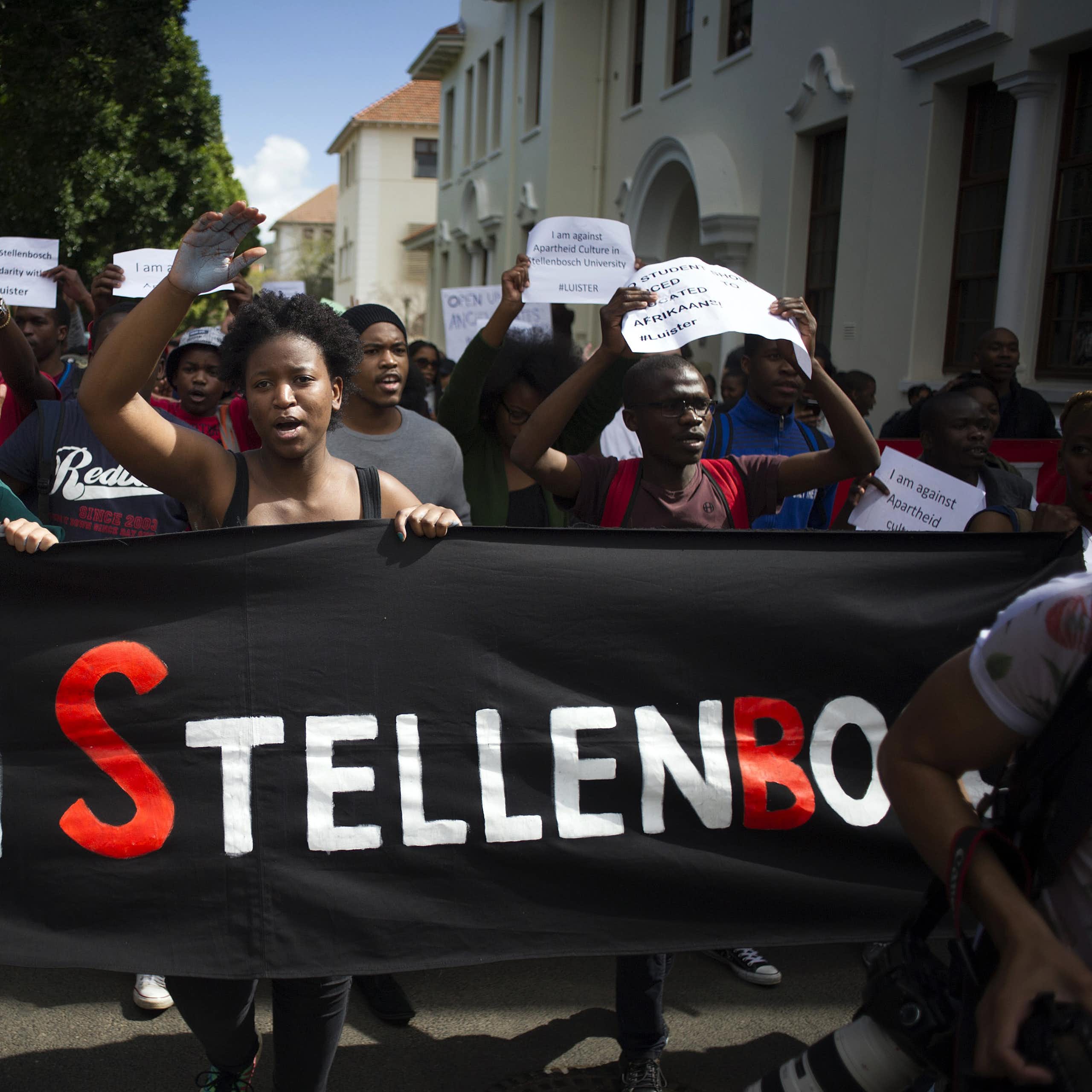 A group of protesters holding a banner that reads Open Stellenbosch. Others are holding placards calling for Afrikaans to be removed as a teaching language
