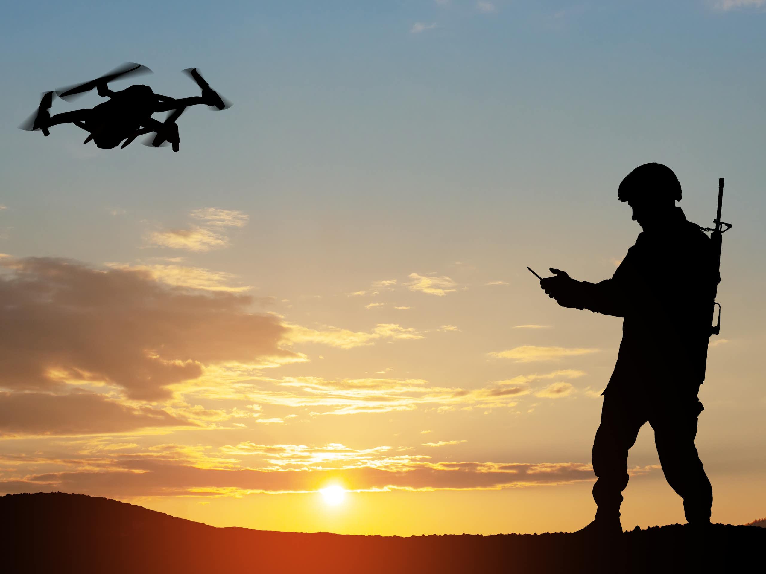 Silhouette of a soldier controlling a drone