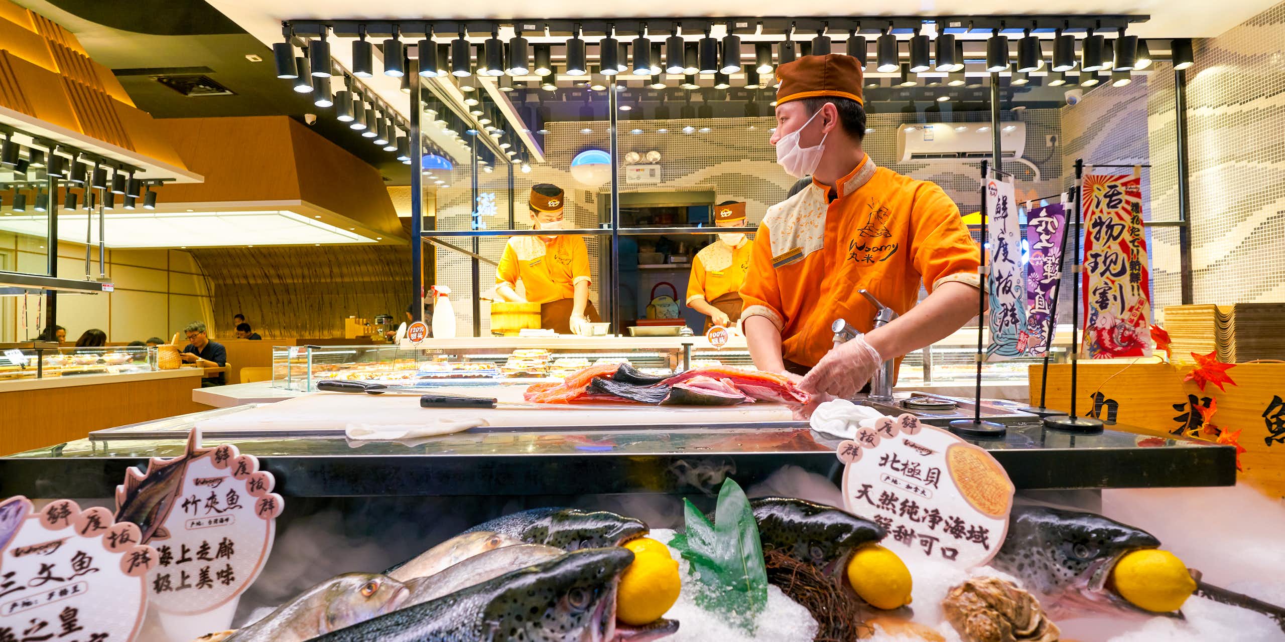 chinese chef preparing salmon in a restaurant kitchen