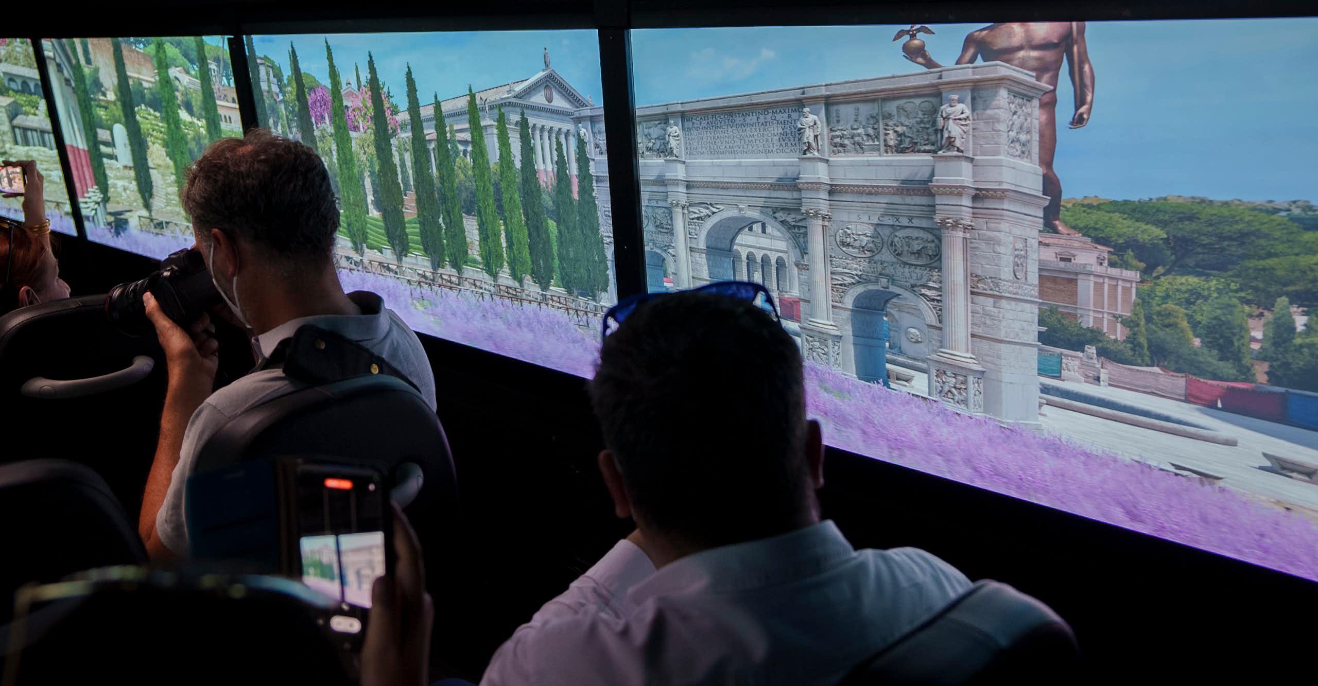 People looking at images of ancient buildings.