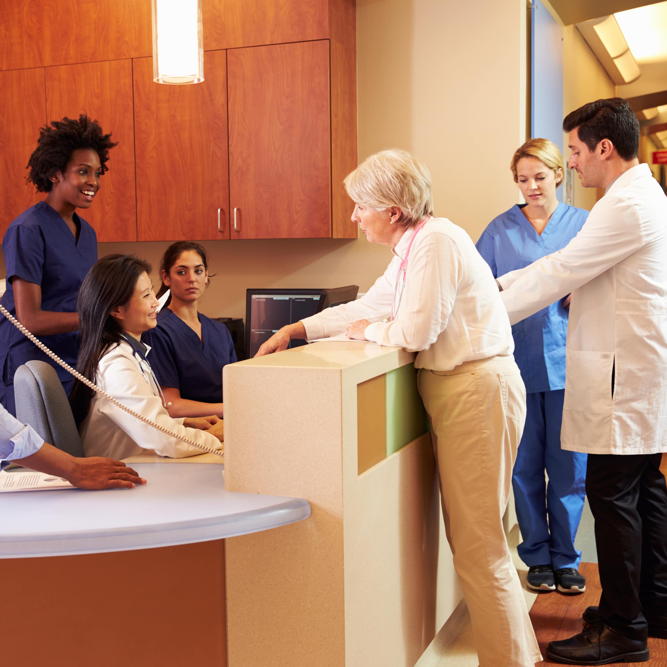 Health-care colleagues gathered at a clinic reception desk