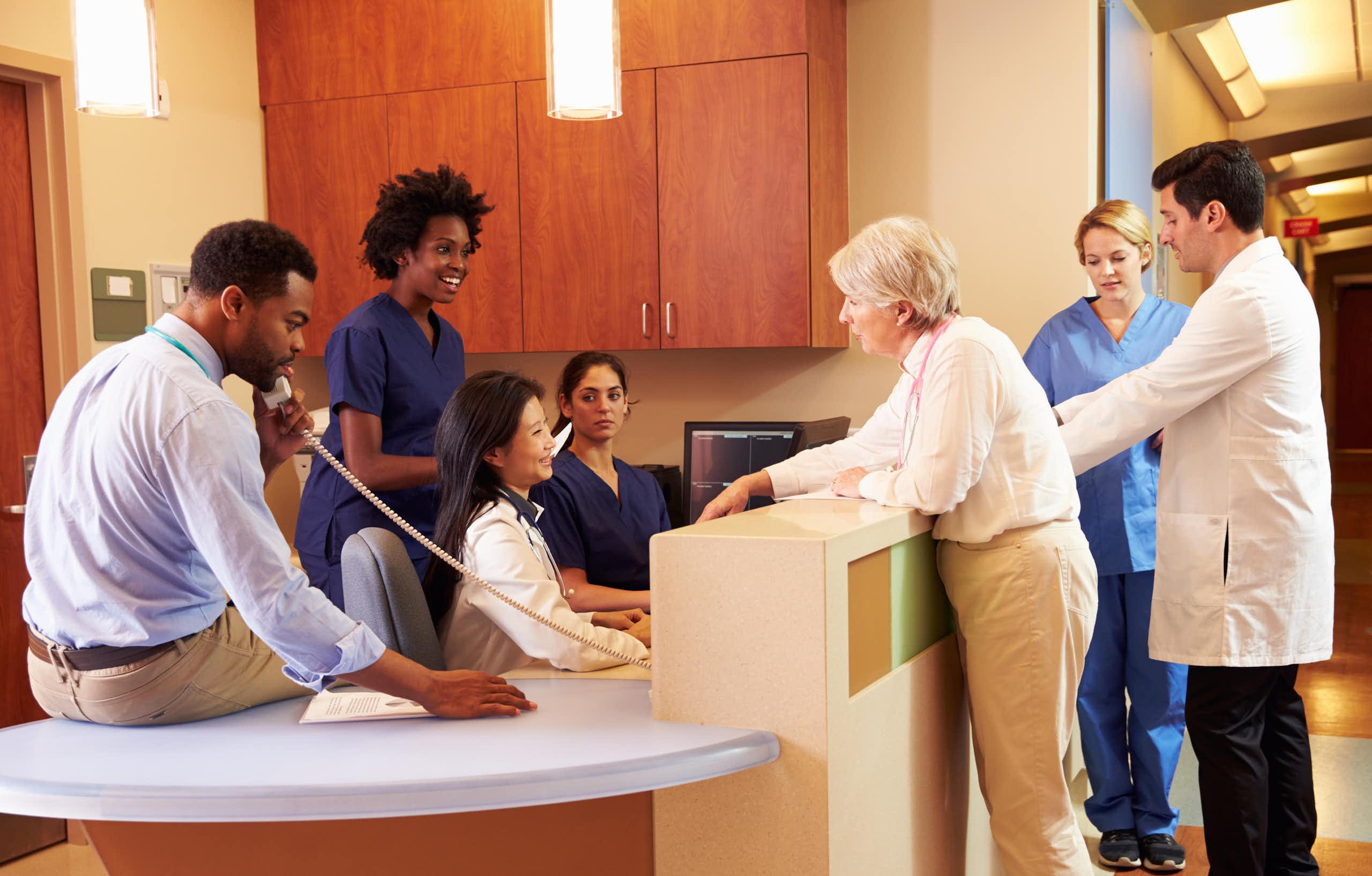 Health-care colleagues gathered at a clinic reception desk