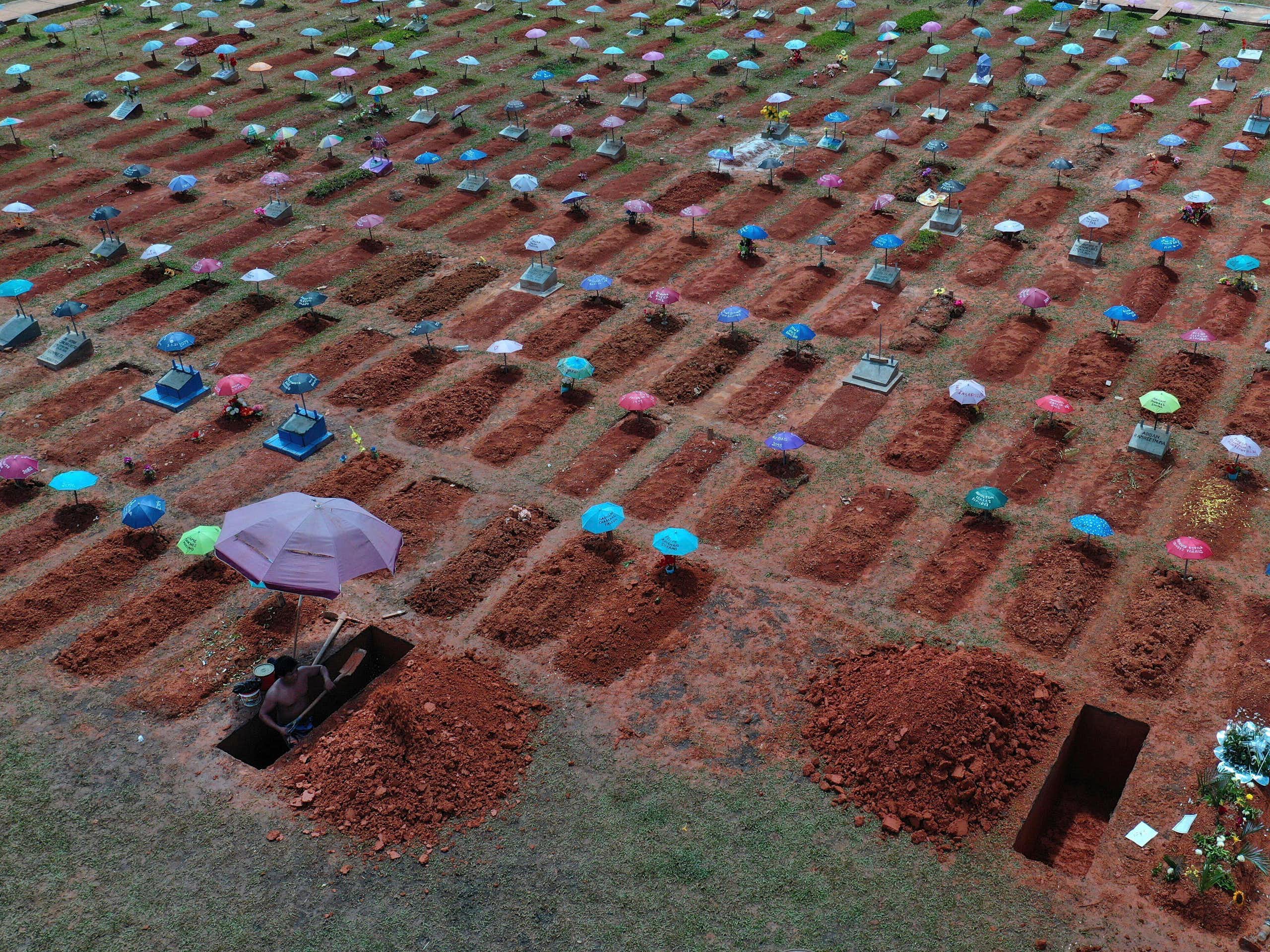 A wide shot of rows and rows of graves dug in fresh dirt.