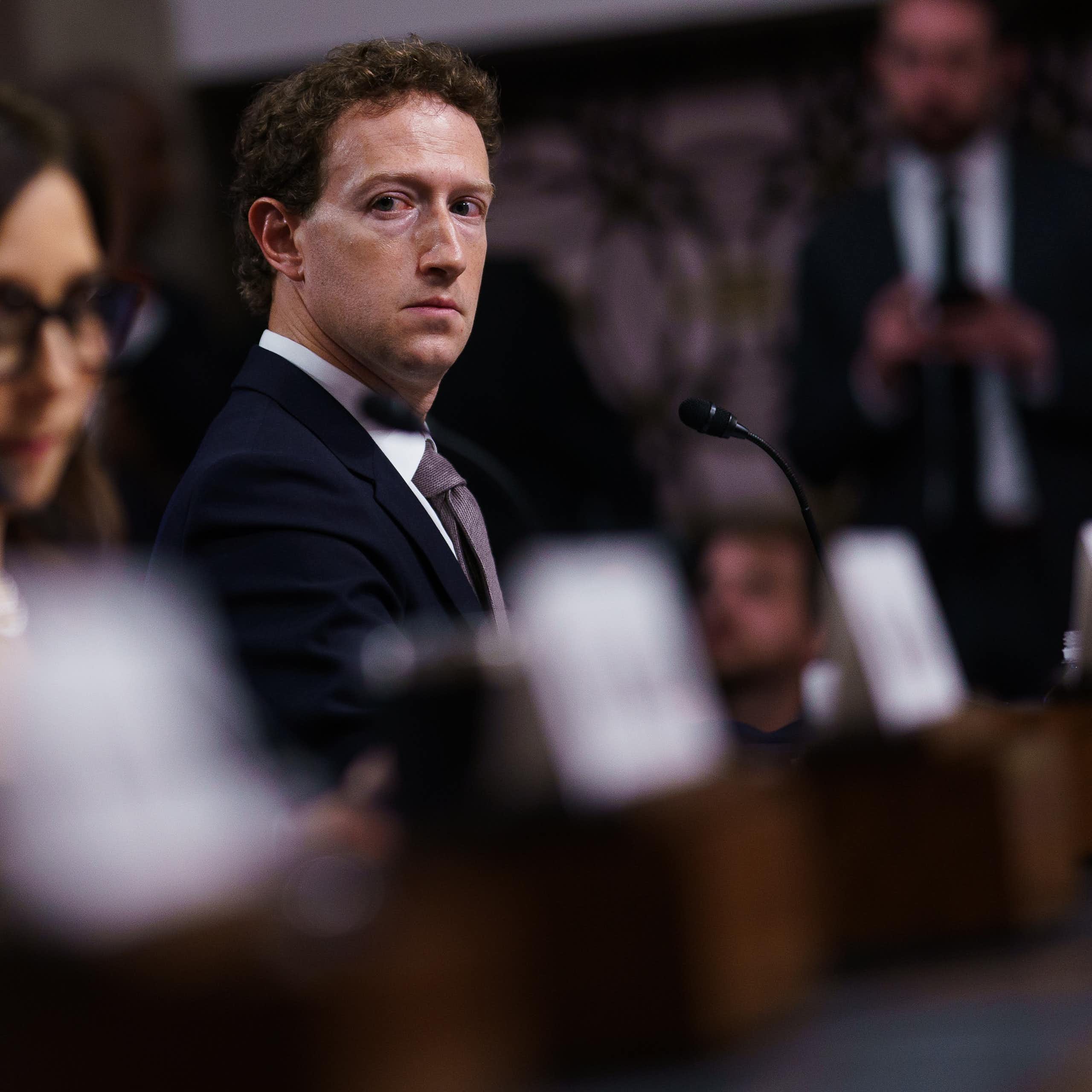 Mark zuckerberg looking solemn, sitting beside other tech executives in the Senate