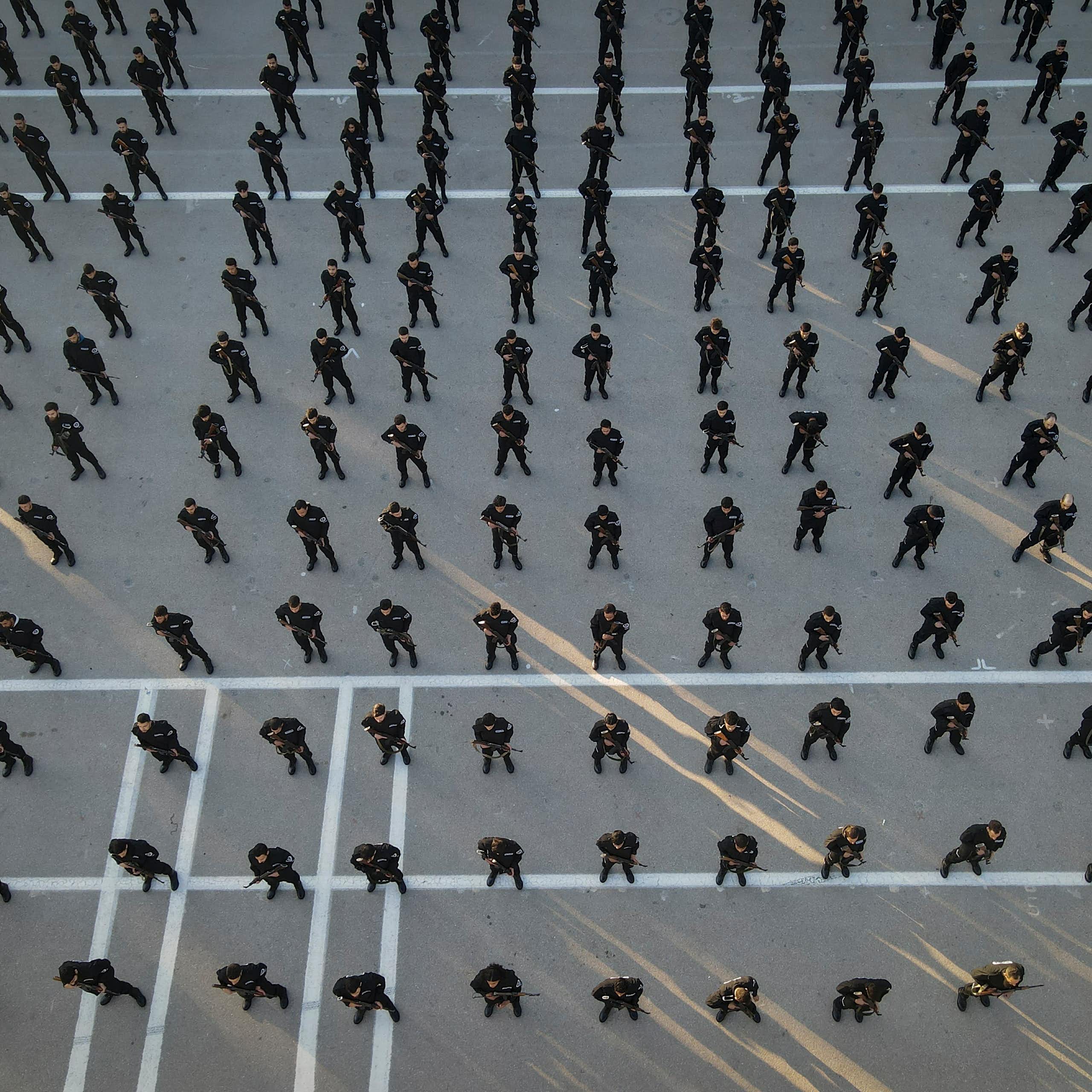 Rows of police recruits photographed from above.