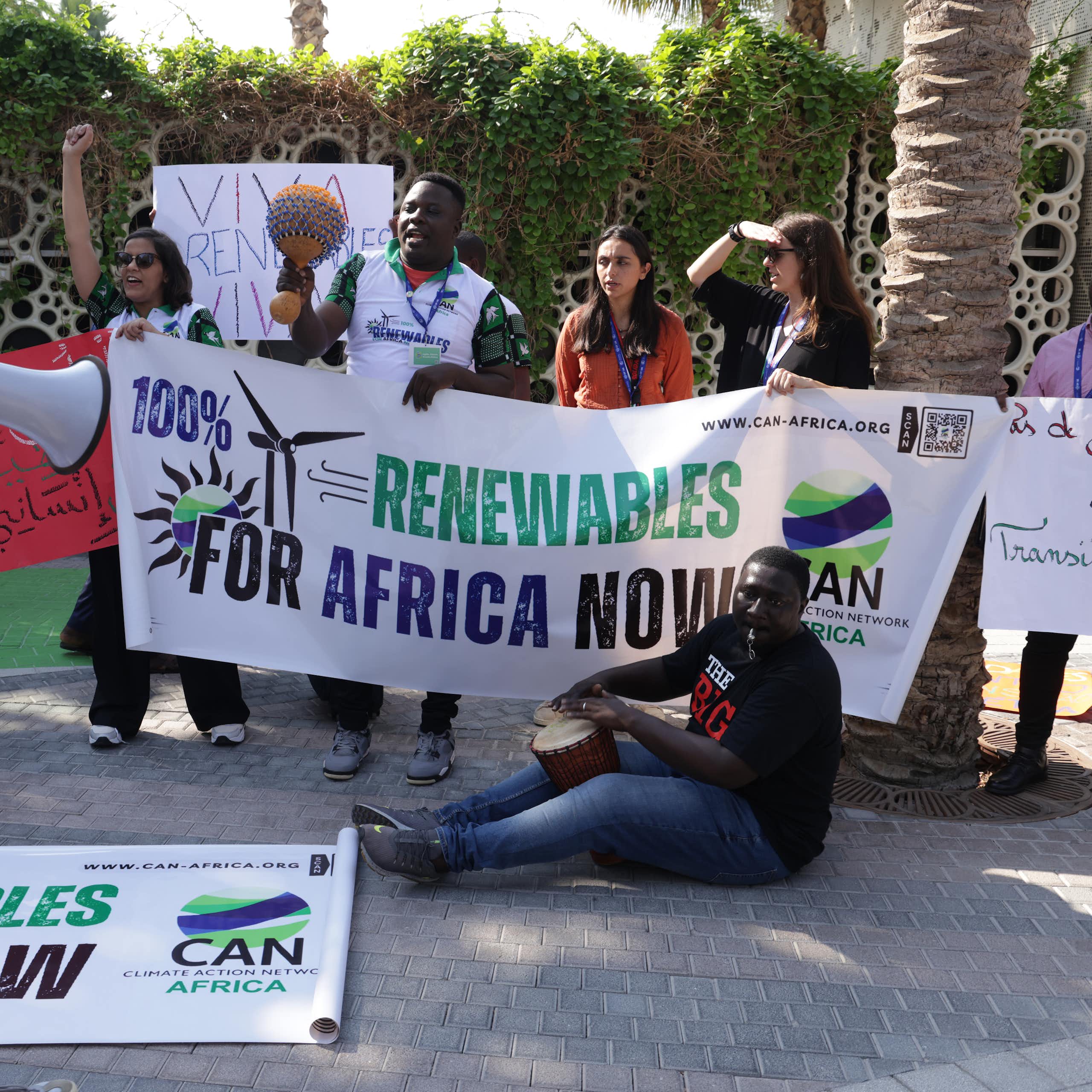 Protesters hold up a banner that says '100% renewables for Africa now'