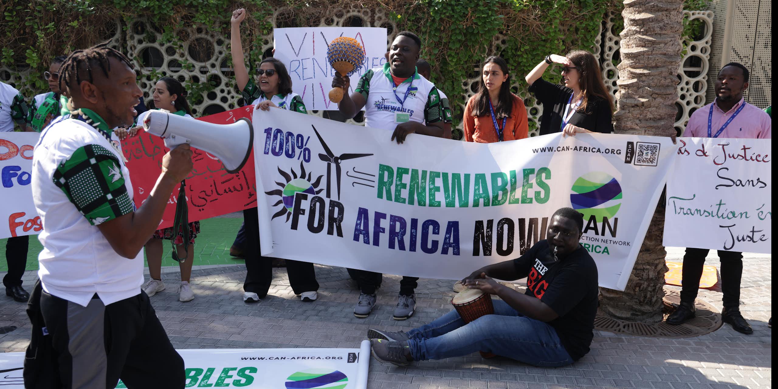Protesters hold up a banner that says '100% renewables for Africa now'
