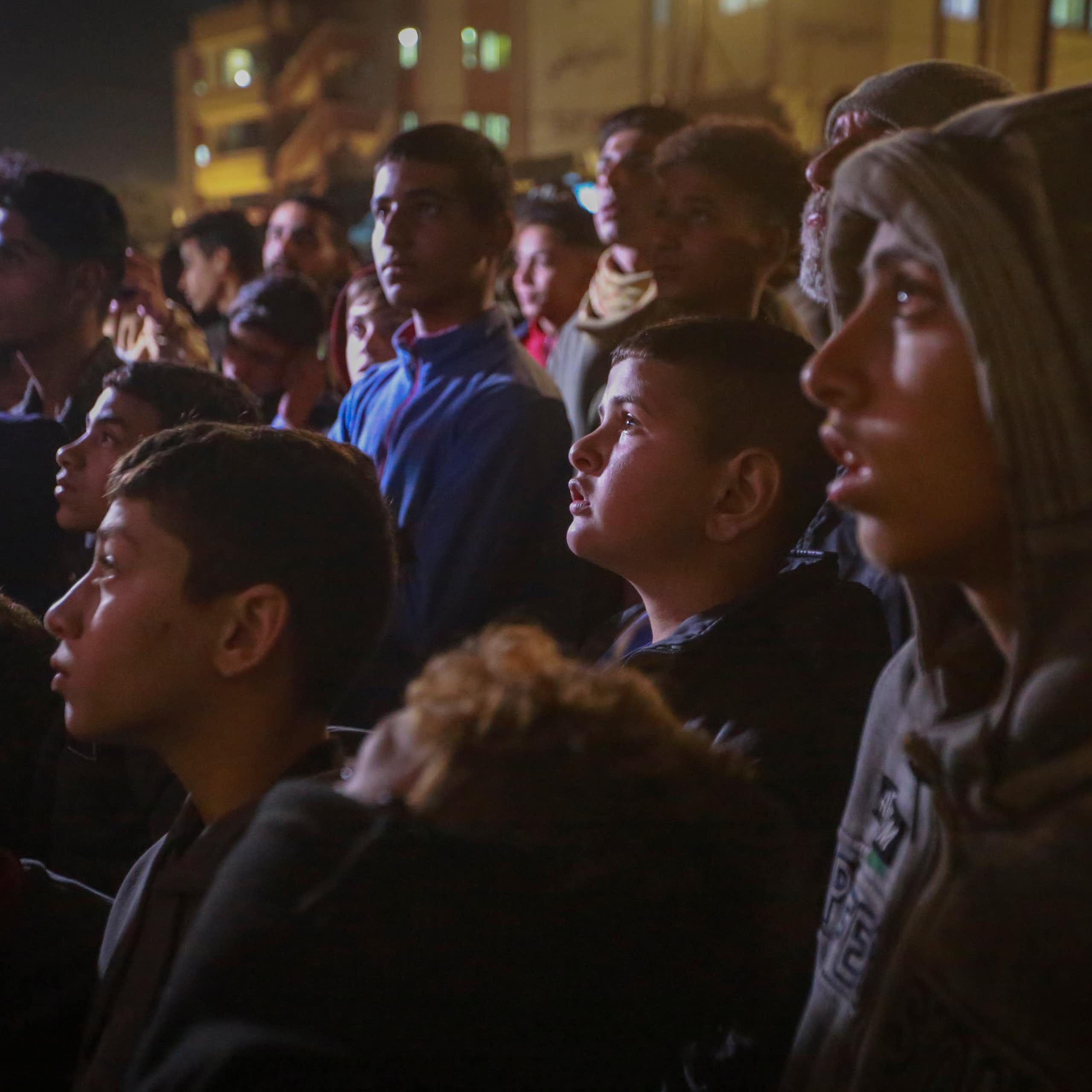 A group of Palestinians watch a TV