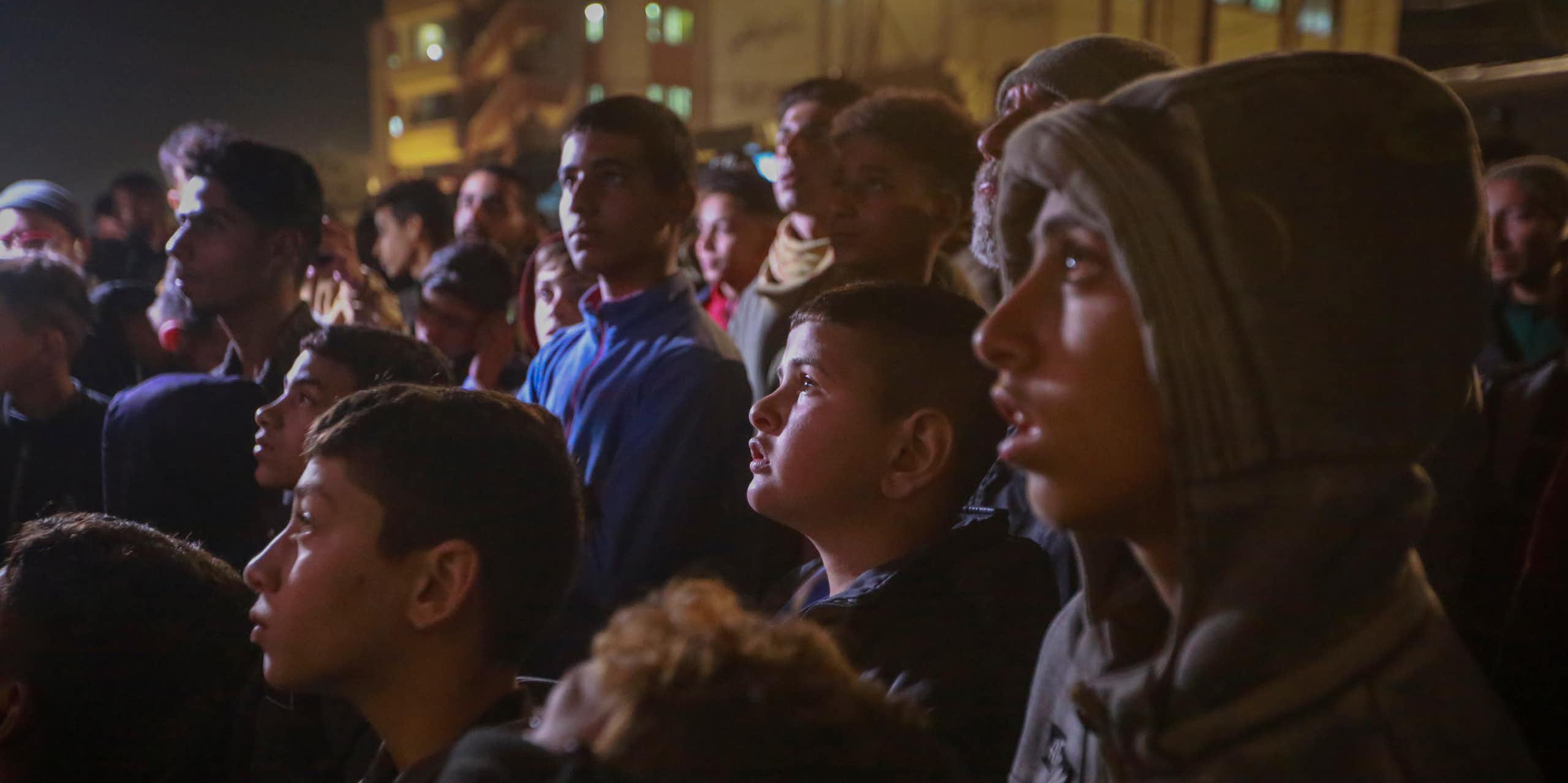 A group of Palestinians watch a TV