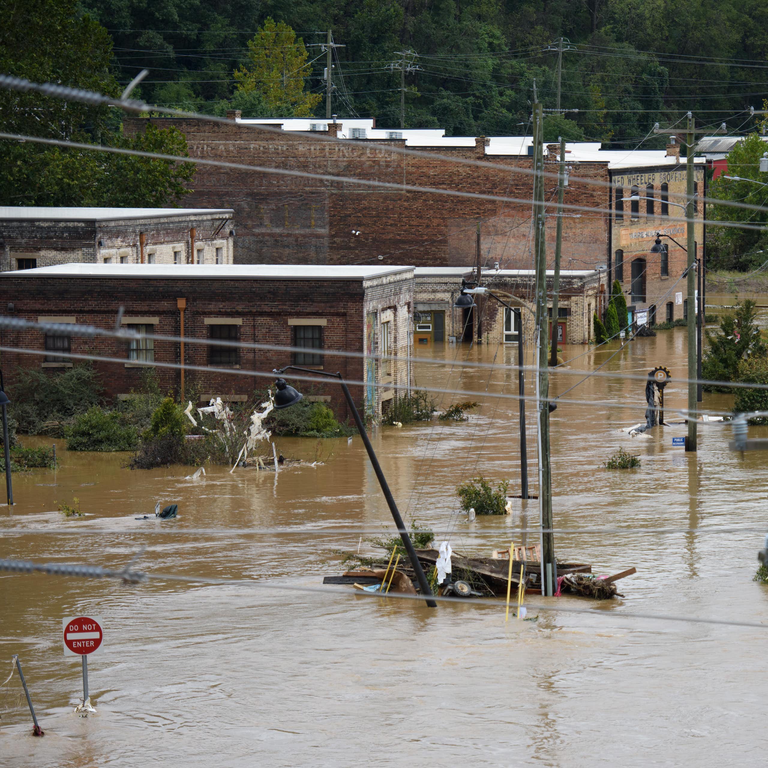 brown flood water covers an intersection with partially flooded brick buildings in the background