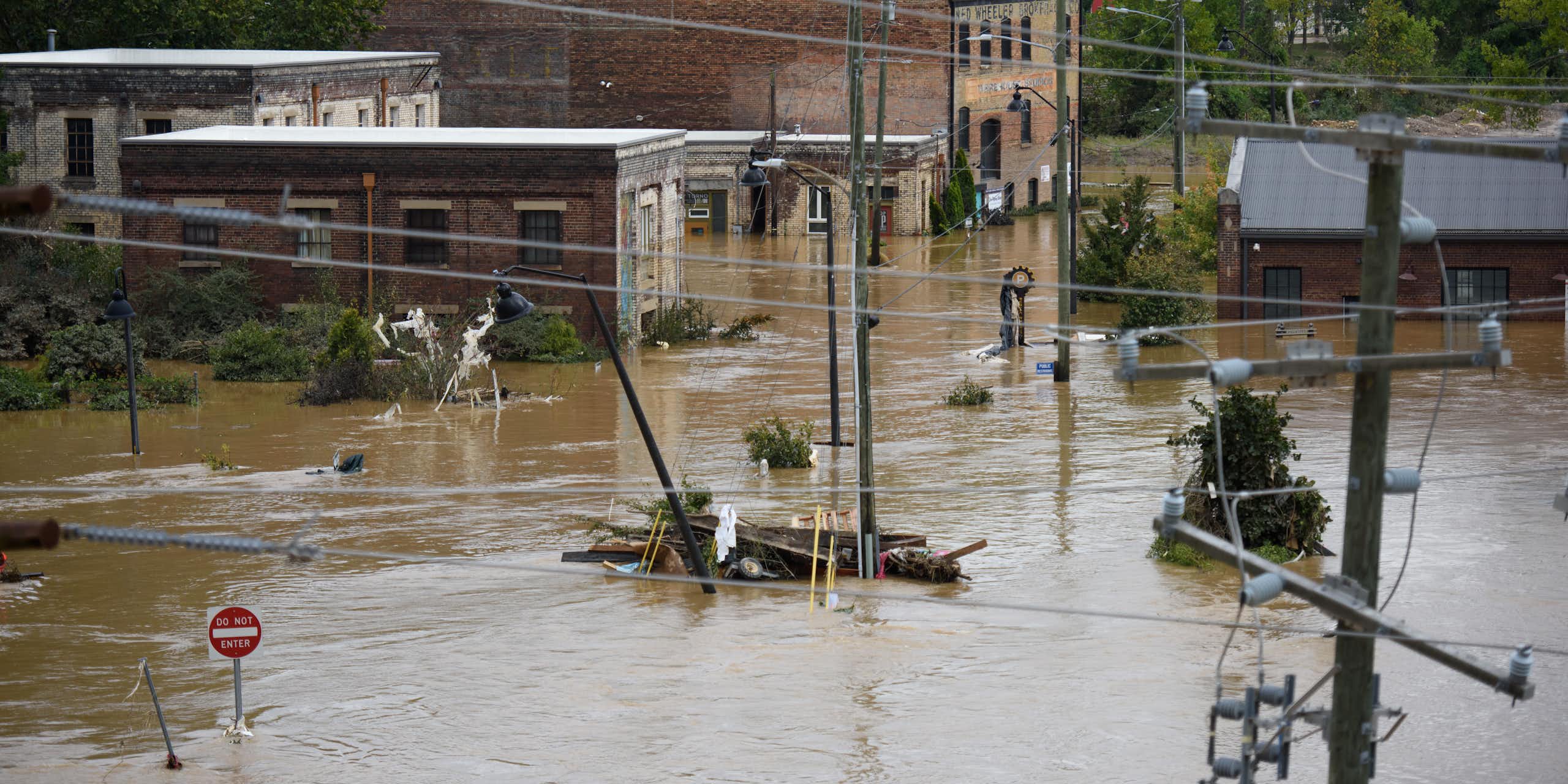 brown flood water covers an intersection with partially flooded brick buildings in the background