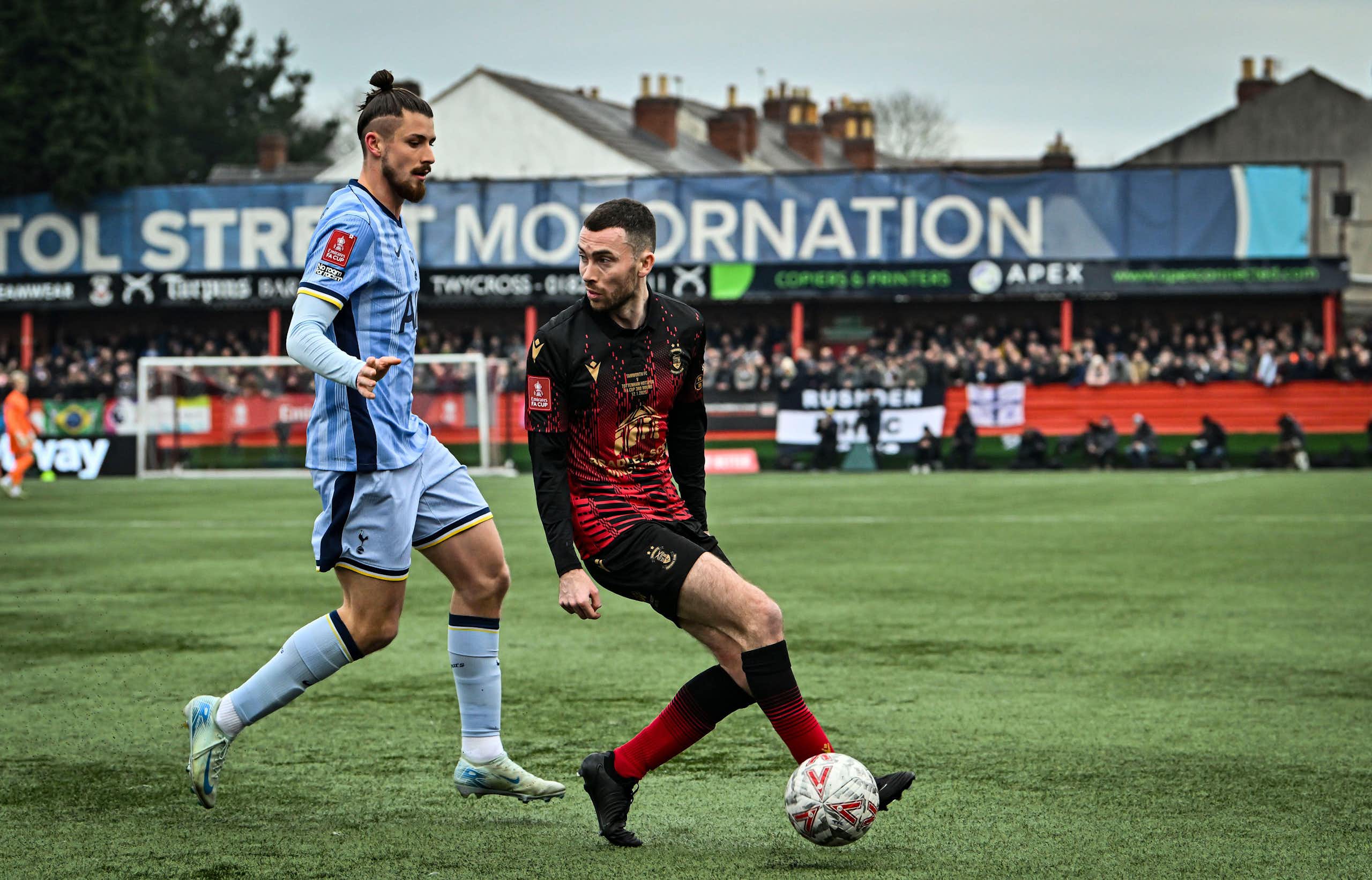 Tamworth footballer Tom McGlinchey, playing football against Tonttenham Hotspurs' Radu Dragusin 