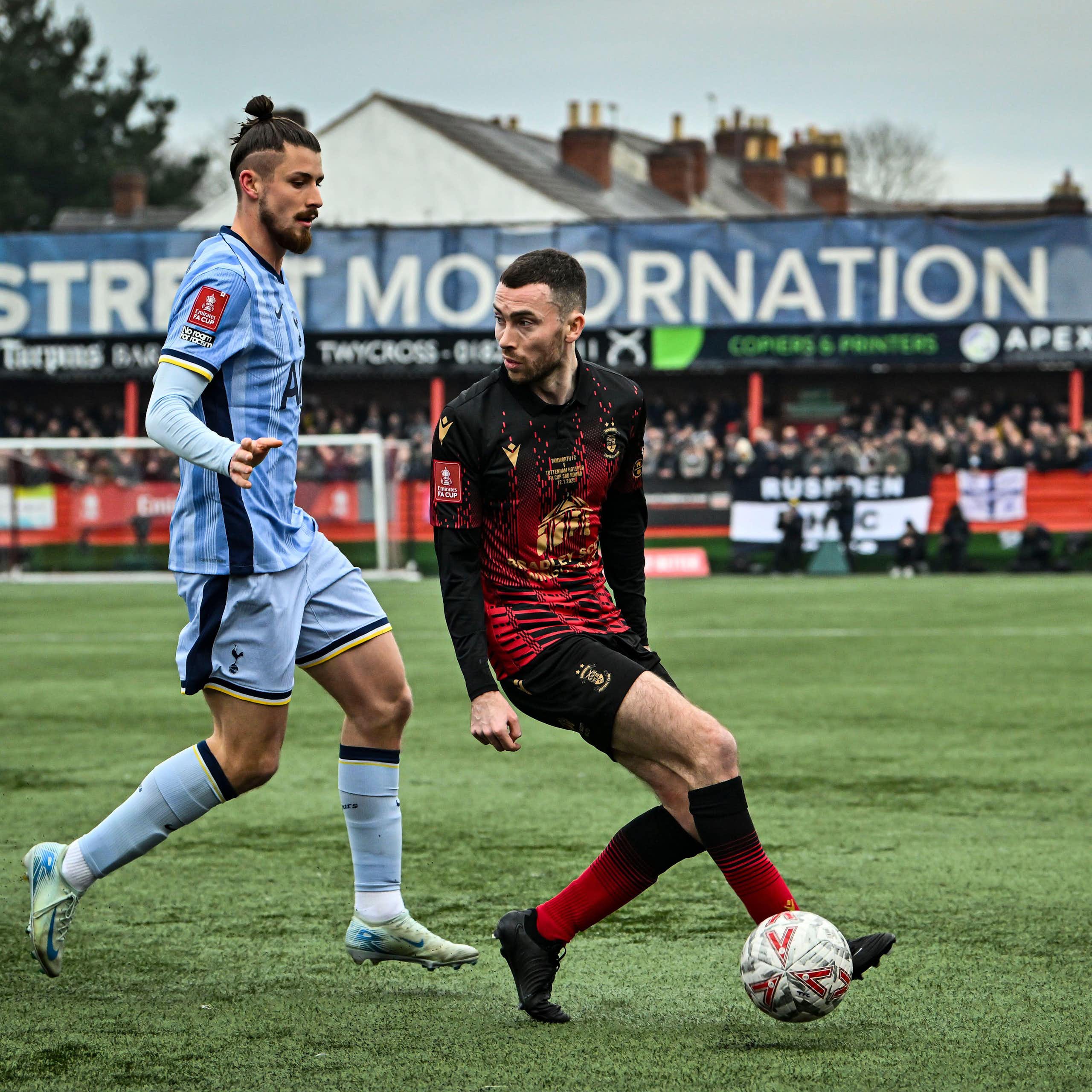 Tamworth footballer Tom McGlinchey, playing football against Tonttenham Hotspurs' Radu Dragusin 