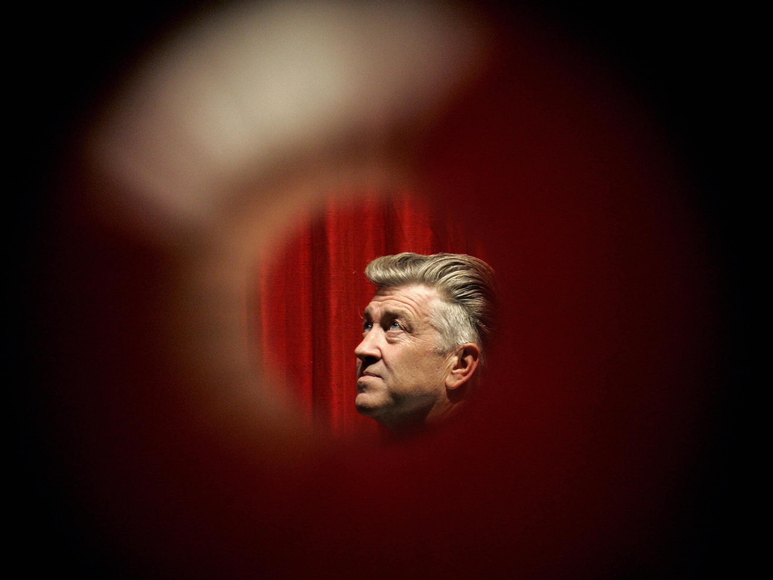 Headshot of man with silver, wavy hair through a peephole.