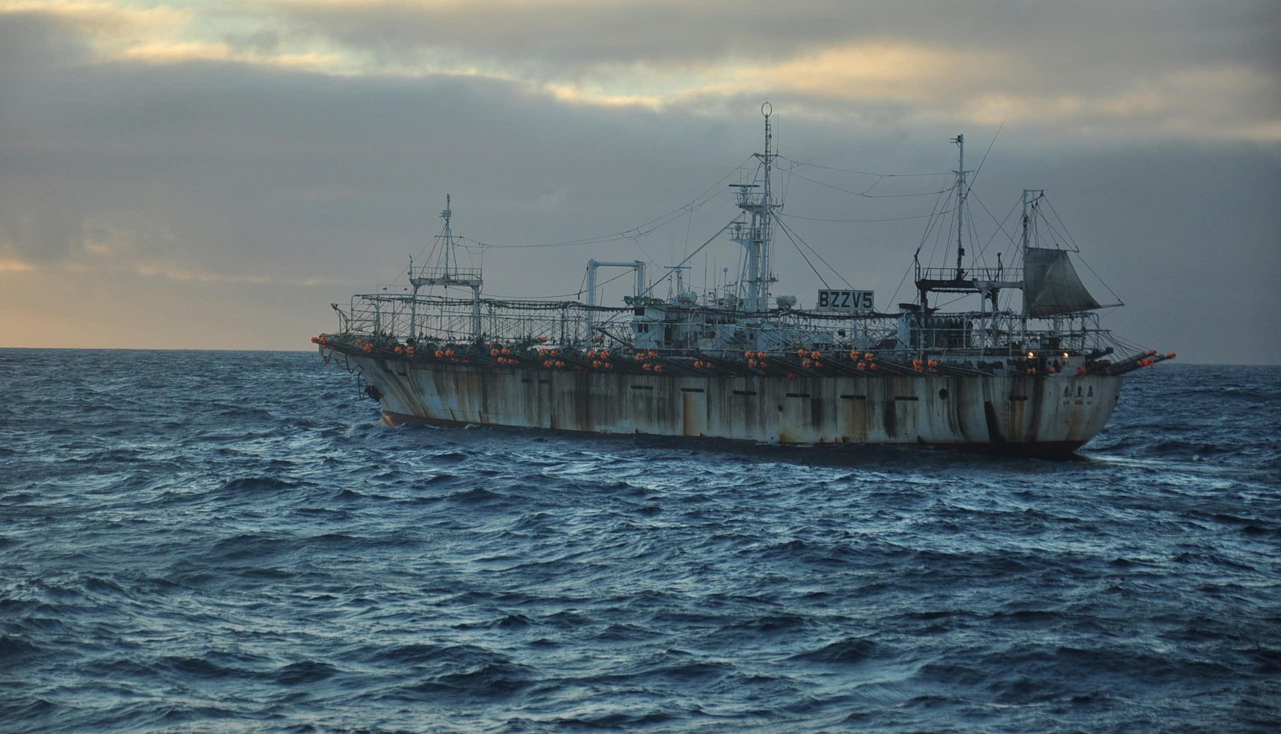 A fishing vessel on the sea at dusk.