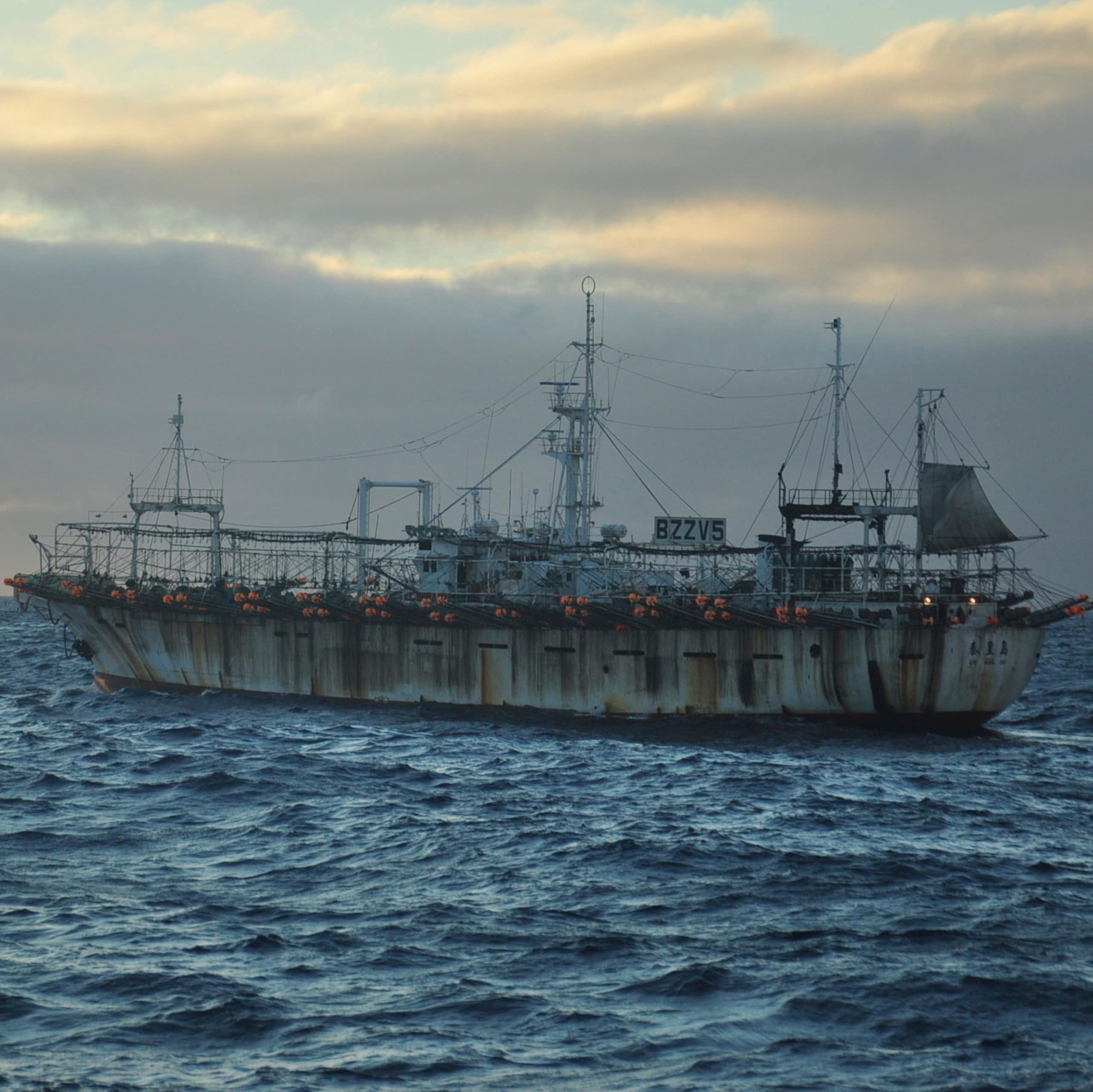 A fishing vessel on the sea at dusk.
