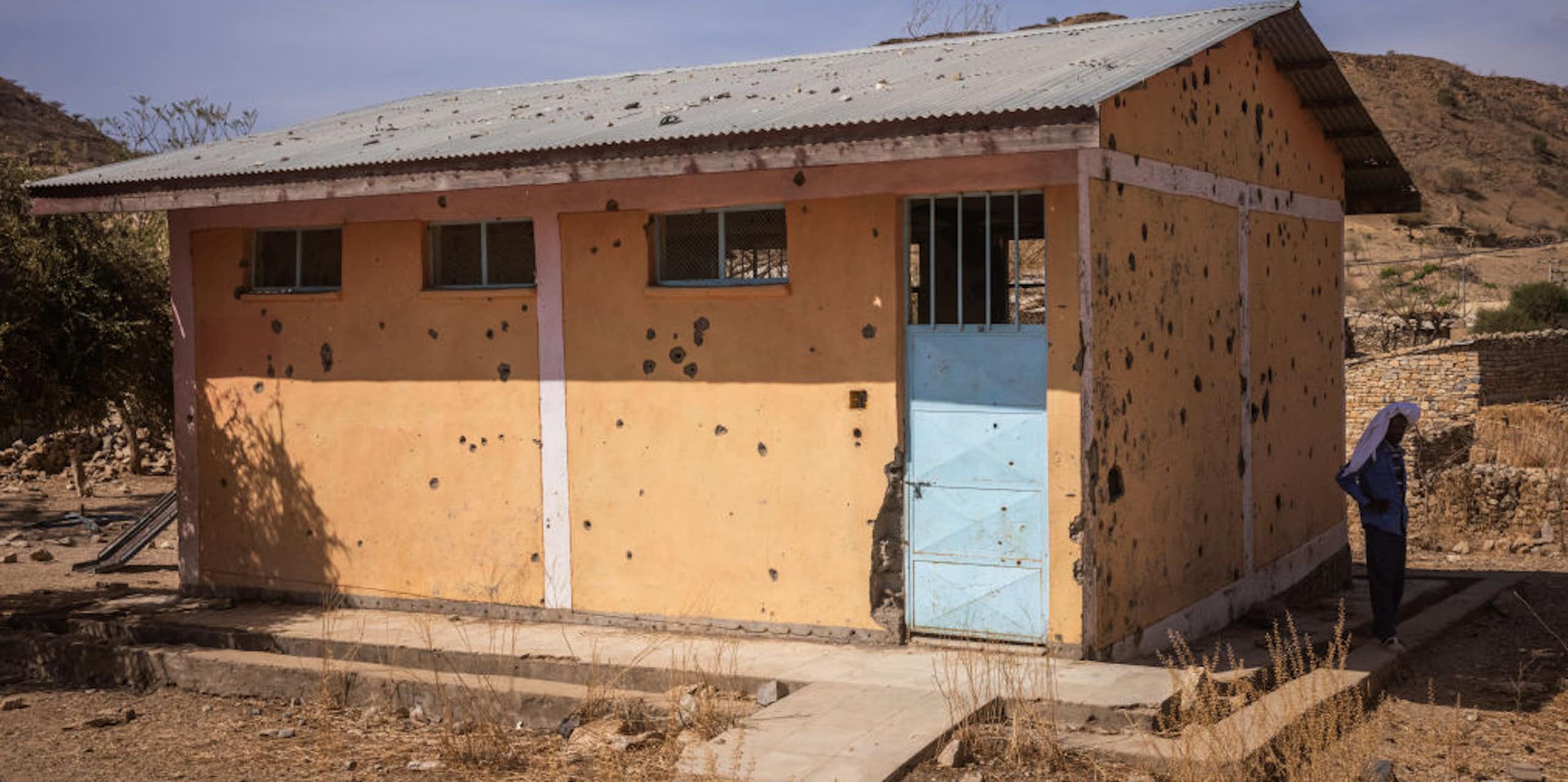 The plastered bullet-riddled school building.