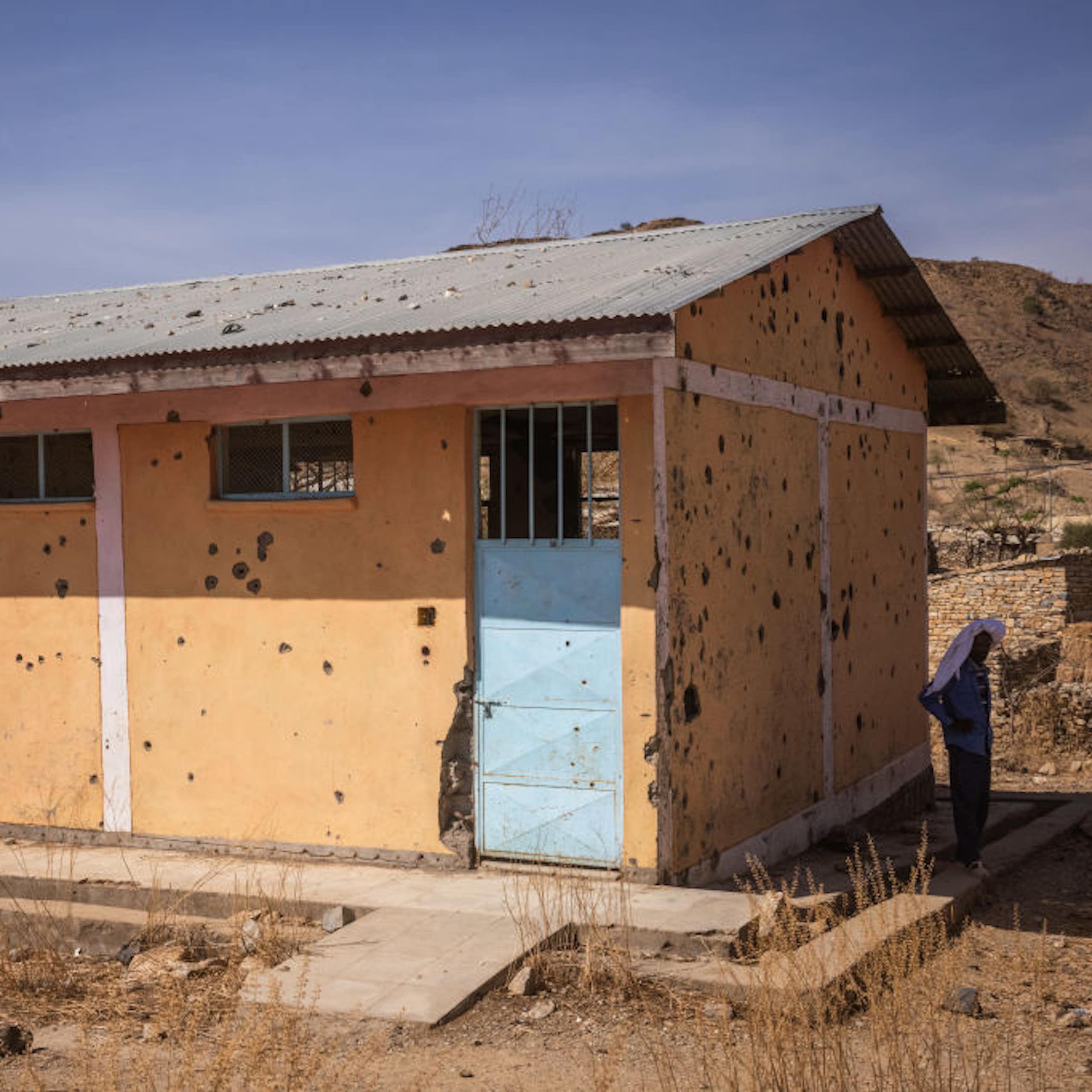The plastered bullet-riddled school building.