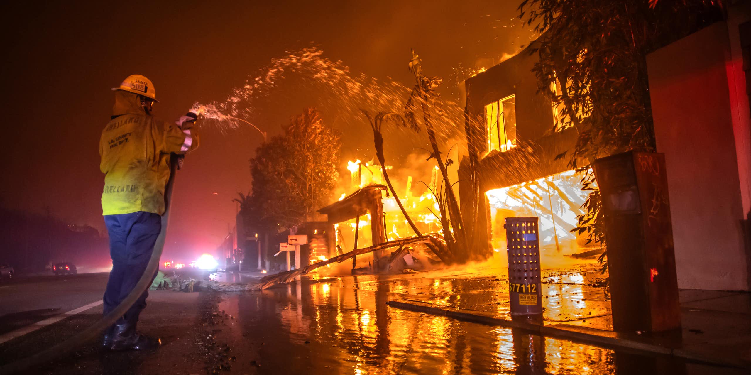 A firefighter battles the Palisades Fire while it burns homes at Pacific Coast Highway.