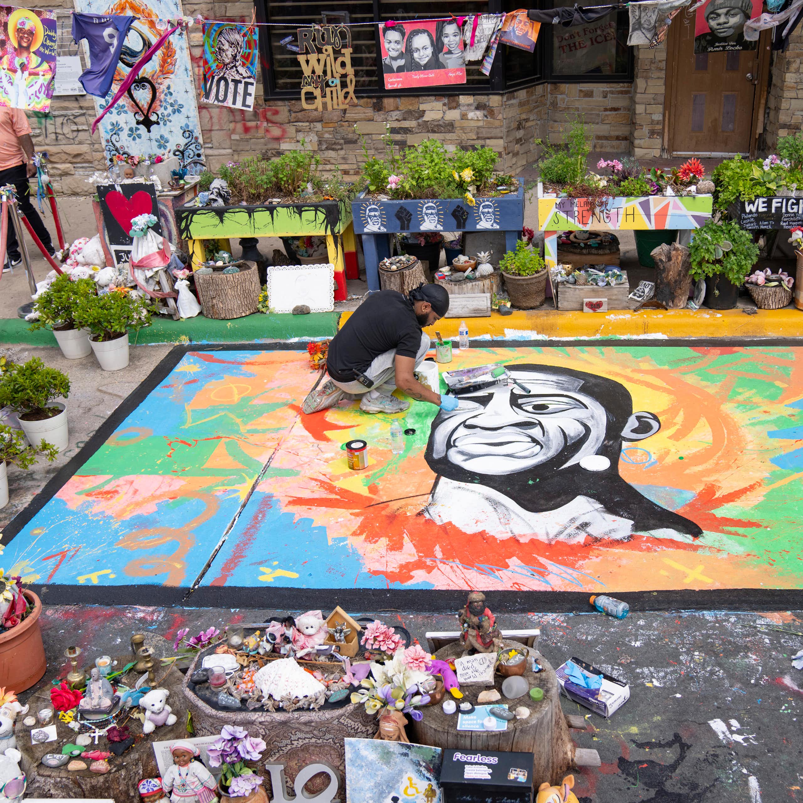 An artist working on a street mural of George Floyd
