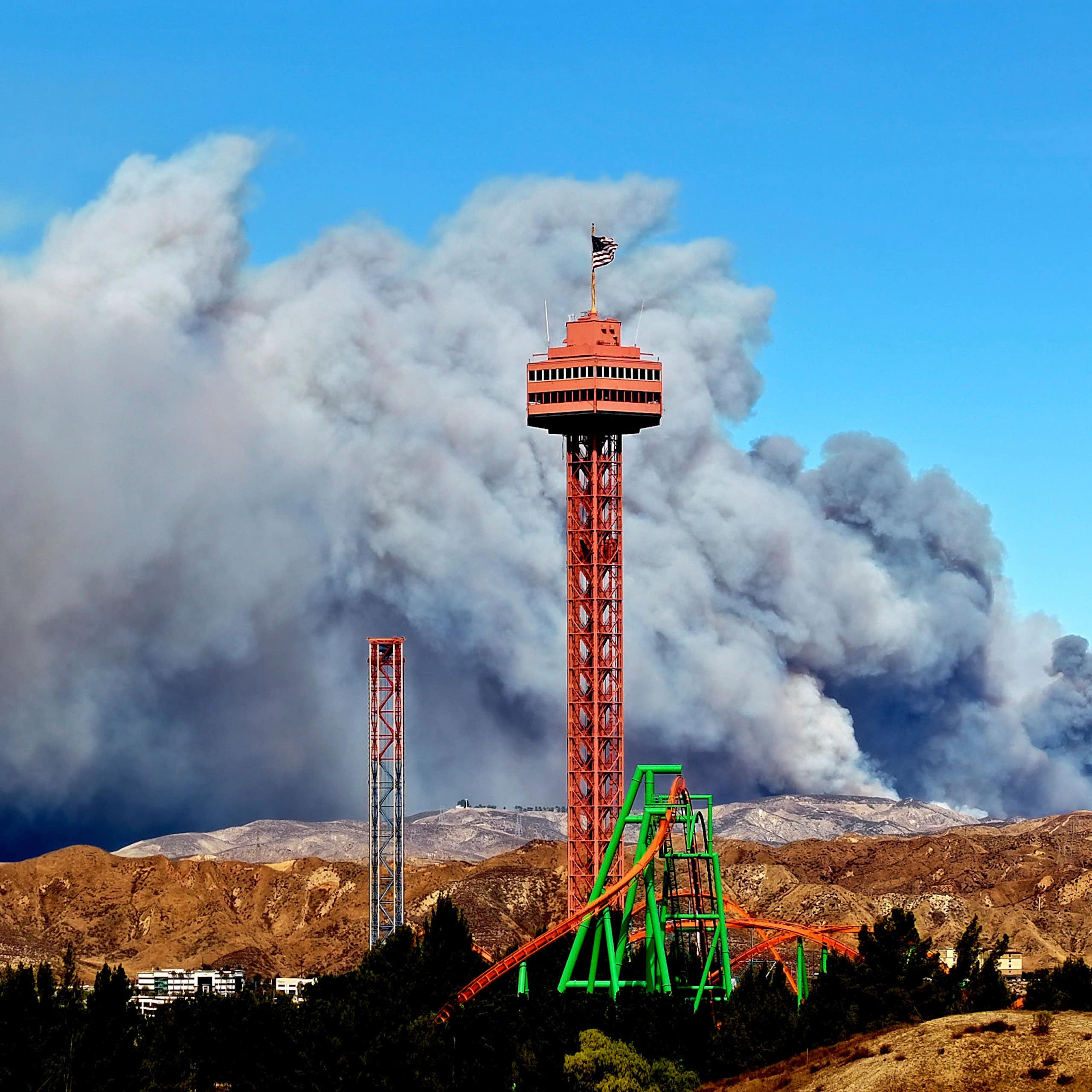 A red tower in front of a huge plume of smoke