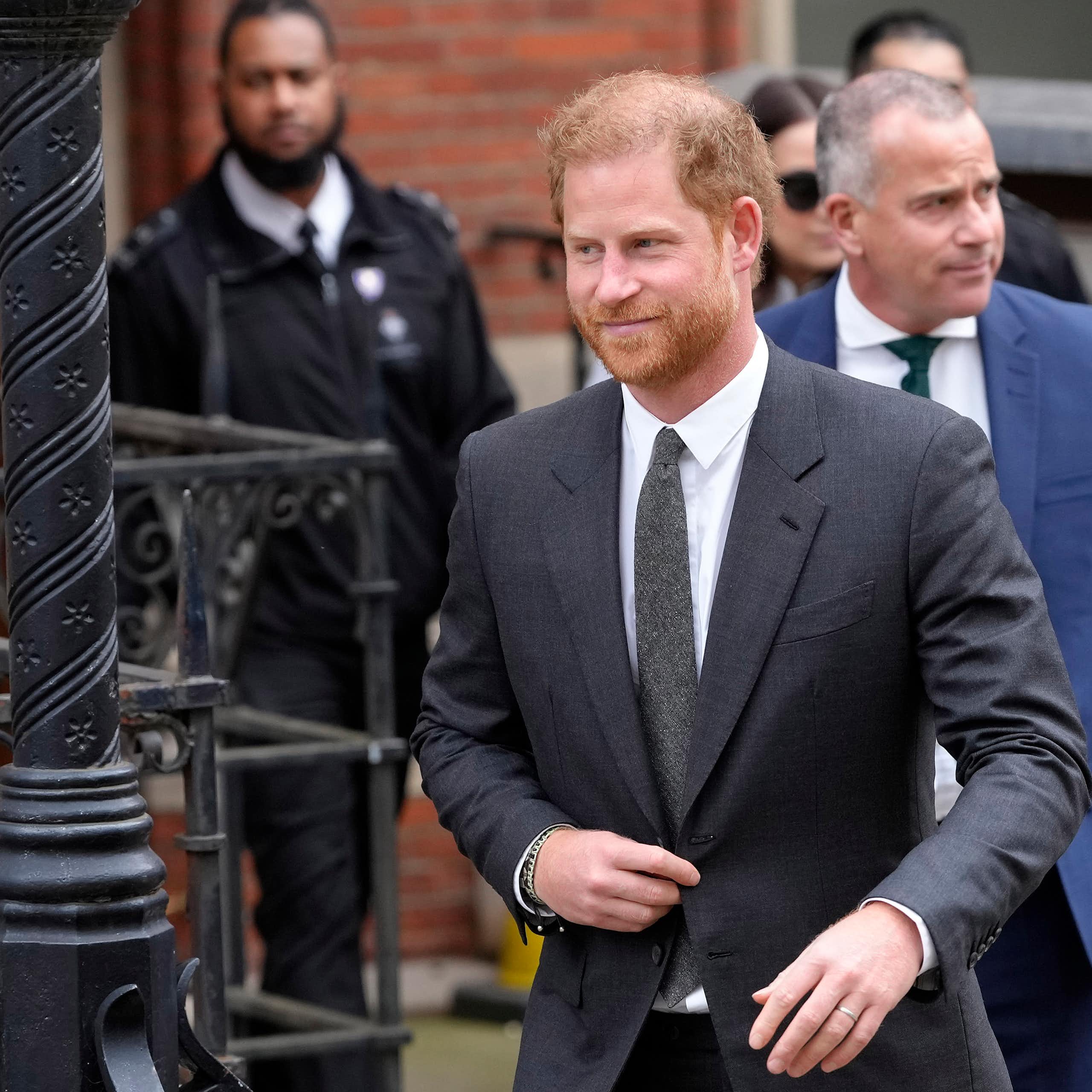 Prince Harry walking out of a brick building