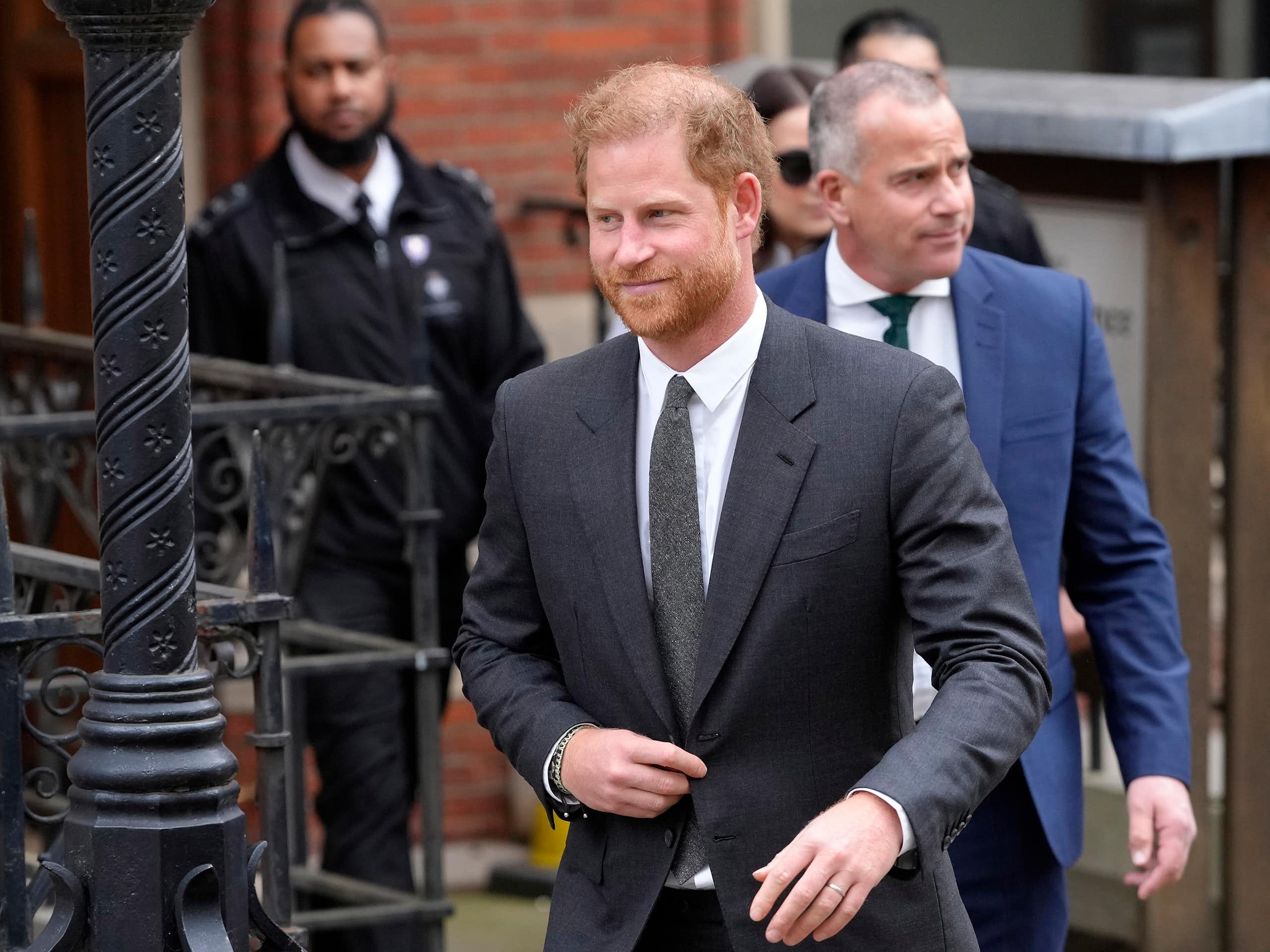 Prince Harry walking out of a brick building