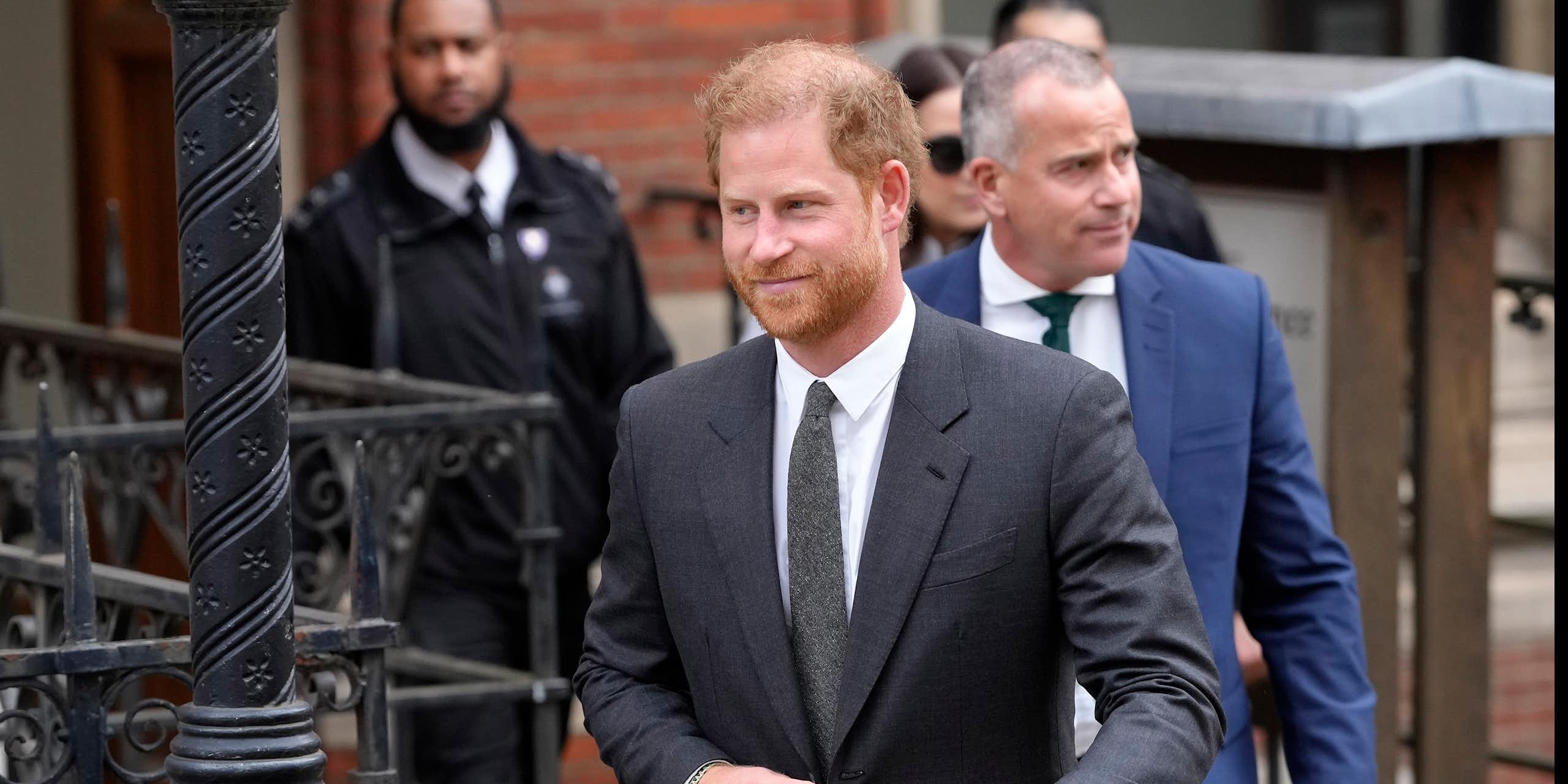 Prince Harry walking out of a brick building