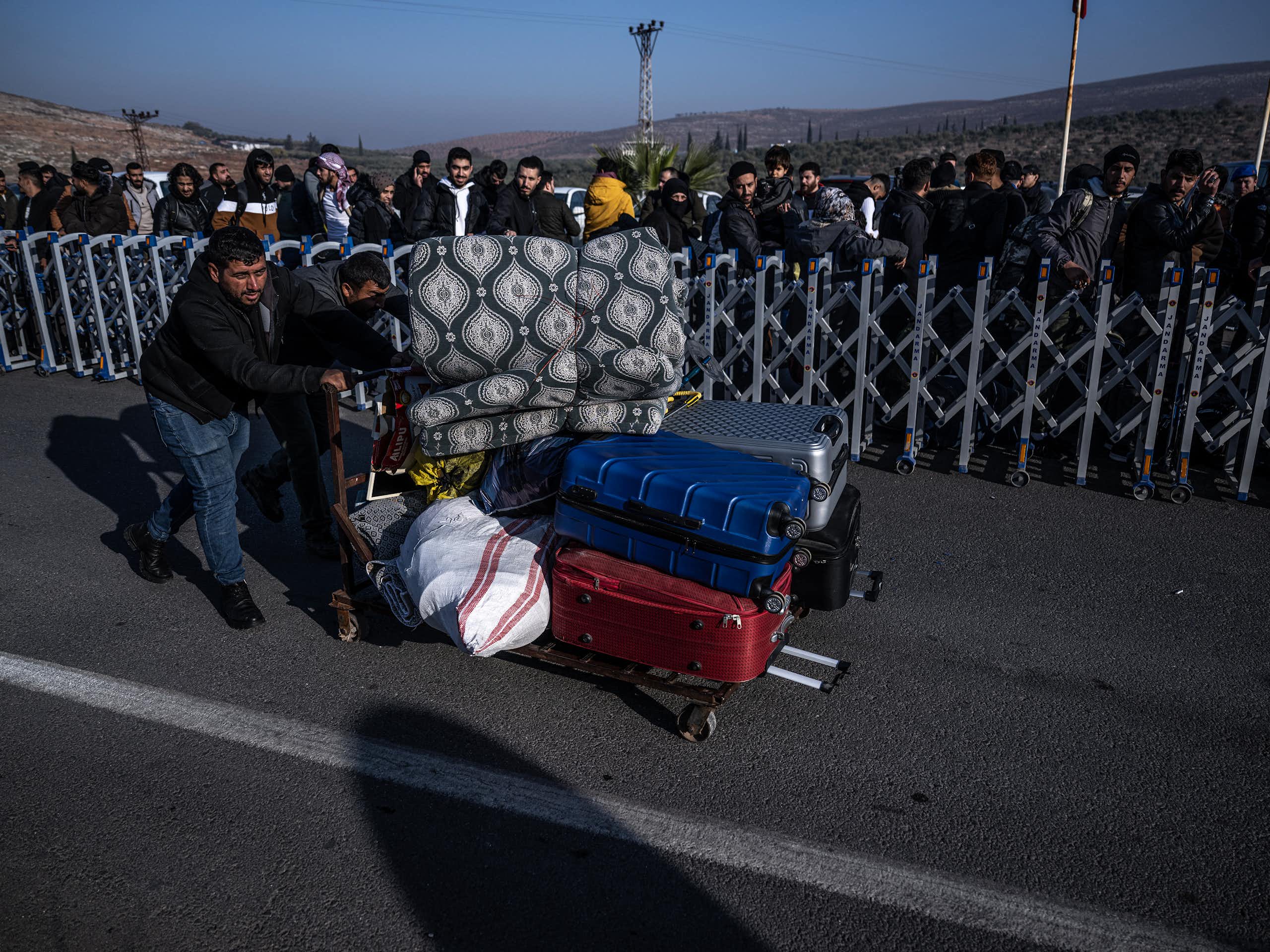 A man pushes a trolley laden with luggage.