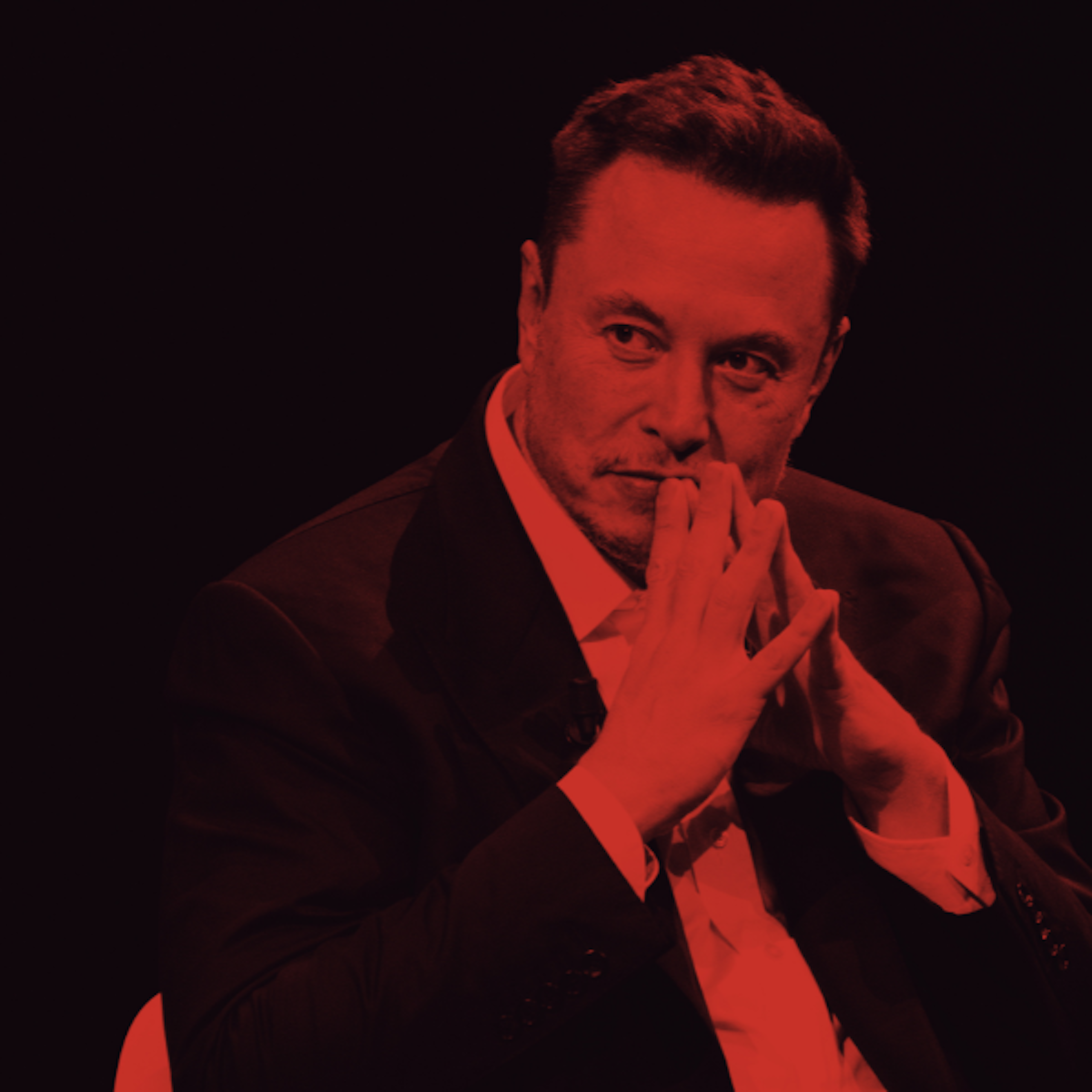 Elon Musk sits with his fingers together